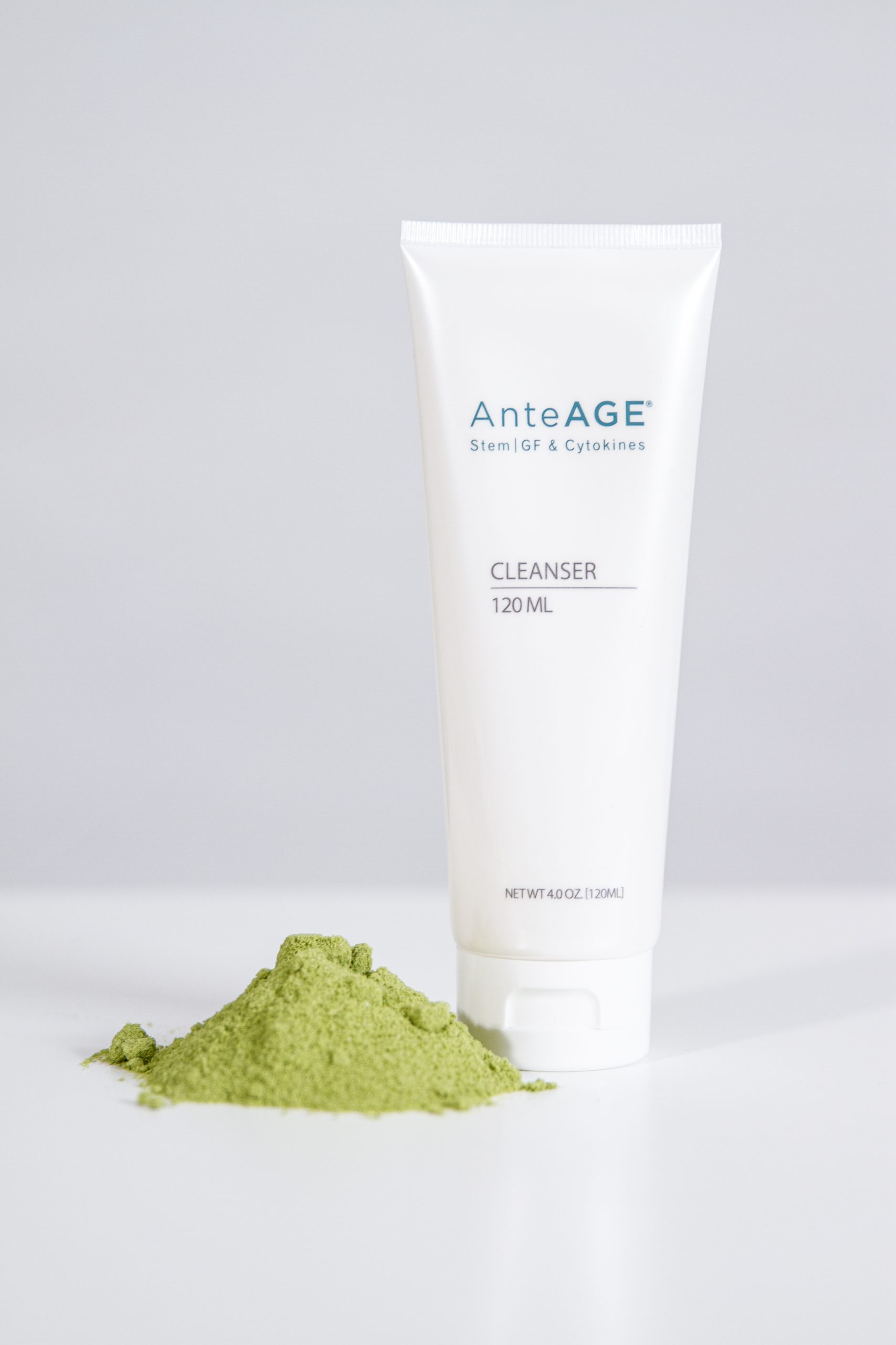 A tube of antiage cleanser powder next to a bowl of green powder at a Medical Center.